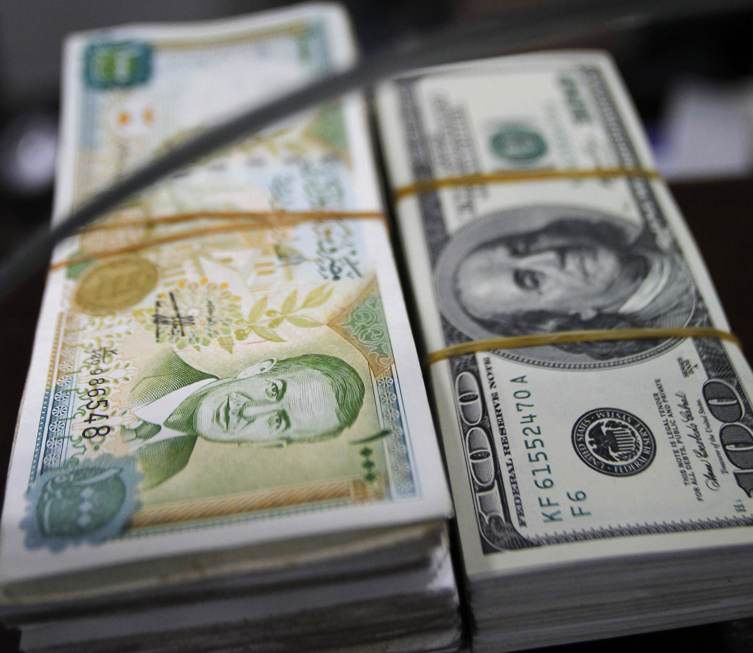 A bundle of Syrian pounds and U.S. dollars is seen in Amman